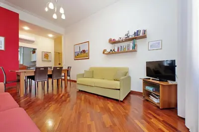 a living room with a couch and a television and a table at 4BNB - Cimabue Apartment in Rome