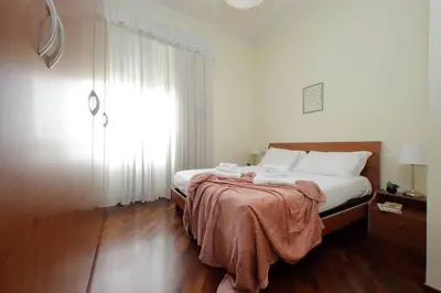 a bedroom with a bed and a large window at 4BNB - Cimabue Apartment in Rome