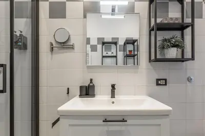 a bathroom with a white sink and a mirror at Imperium House - appartamento con giardino privato, 3 minuti da Metro Piazza Bologna, A-C, in Rome