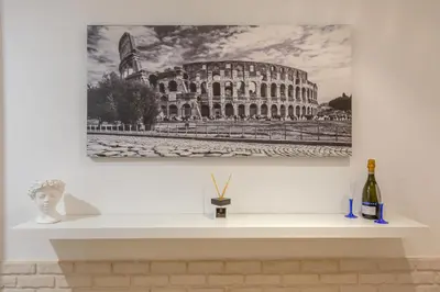 a picture of the coliseum and a bottle of wine on a shelf at Imperium House - appartamento con giardino privato, 3 minuti da Metro Piazza Bologna, A-C, in Rome