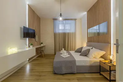a bedroom with a large bed and a television at Imperium House - appartamento con giardino privato, 3 minuti da Metro Piazza Bologna, A-C, in Rome