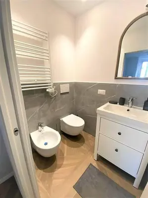 a bathroom with a sink and a toilet and a mirror at La casa di Jonathan al Ghetto in Rome