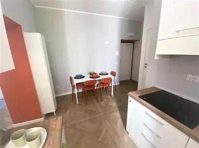 a kitchen with a table and chairs in a room at La casa di Jonathan al Ghetto in Rome