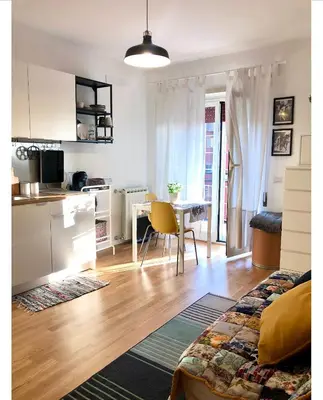 a living room with a kitchen and a dining room table at A Casa di Lele in Rome