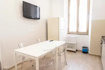 a room with a white table and a tv on the wall at Domus Viola in San Giovanni in Rome