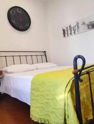 a bedroom with a bed with a clock on the wall at Casetta del Quadraro in Rome