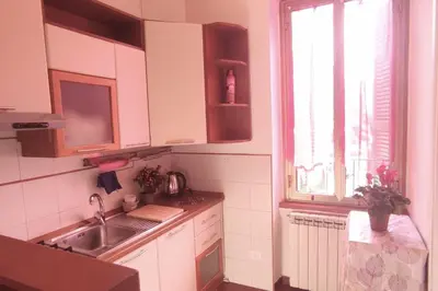 a kitchen with white cabinets and a sink and a window at Casetta del Quadraro in Rome