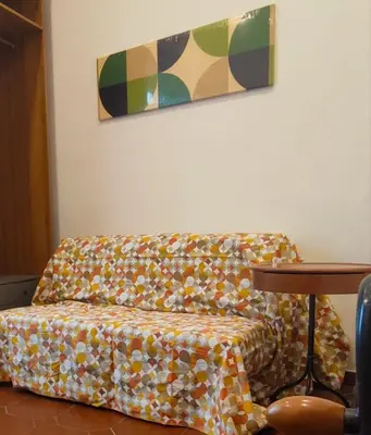 a couch sitting in a living room with a painting at Casetta del Quadraro in Rome