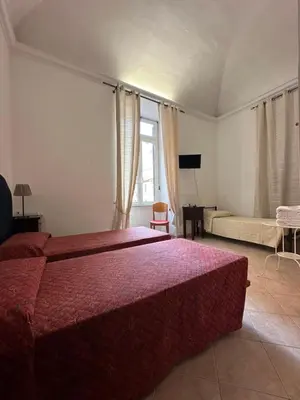 a bedroom with a red bed and a couch at Alloggio Turistico in Rome