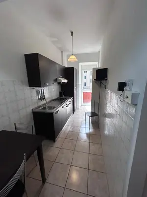 a kitchen with a sink and a table in it at Ragusa Holiday Home in Rome