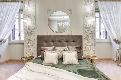 a bedroom with a large bed and a mirror at White Miracle Suite in Rome