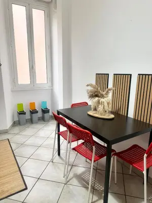 a dining room with a black table and red chairs at Voluptas house Trastevere Testaccio in Rome