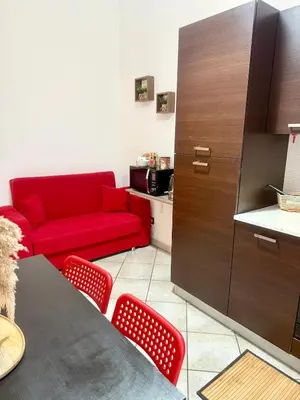 a living room with a red couch and a table at Voluptas house Trastevere Testaccio in Rome