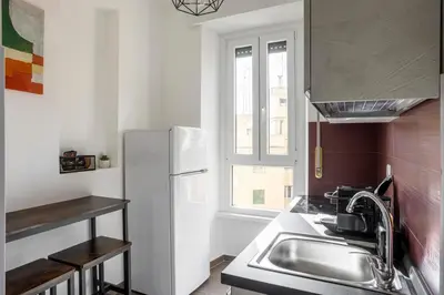 a kitchen with a sink and a refrigerator at Maison del Re - San Giovanni by RHR in Rome