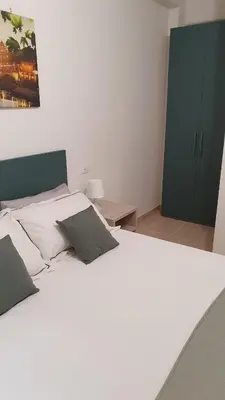 a bedroom with a large white bed and a green cabinet at Melory House in Rome