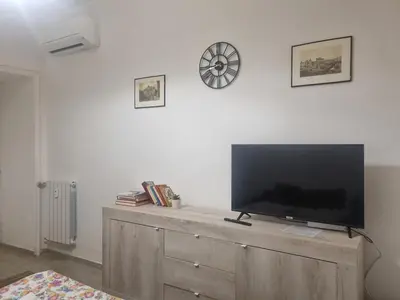 a flat screen tv sitting on top of a wooden dresser at Ad un passo dal Vaticano in Rome