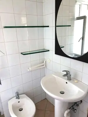 a white bathroom with a sink and a mirror at Casa Aurelia in Rome