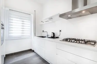 a white kitchen with a stove and a window at BBHOME Tiburtina Station apartment in Rome