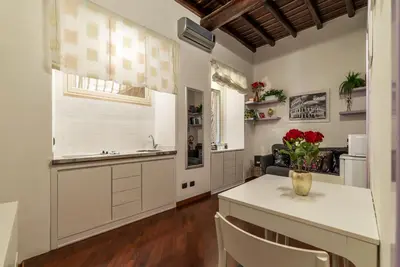 a kitchen with white cabinets and a table and chairs at GuestHost - Lovely Apartment ad un passo da Piazza del Popolo! in Rome