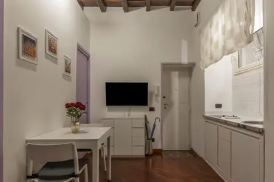 a kitchen with a table and a tv on a wall at GuestHost - Lovely Apartment ad un passo da Piazza del Popolo! in Rome