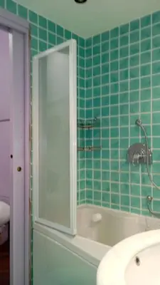 a green tiled bathroom with a tub and a sink at GuestHost - Lovely Apartment ad un passo da Piazza del Popolo! in Rome