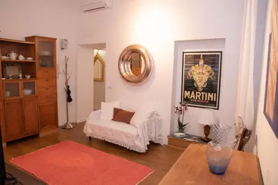 a living room with a white chair and a table at pantheon luxury apartment in Rome