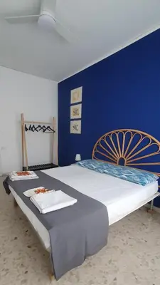 a bedroom with a large bed with a blue wall at Casa Carbone in Rome