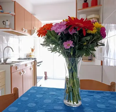 a vase of flowers sitting on a table in a kitchen at Casa Carbone in Rome