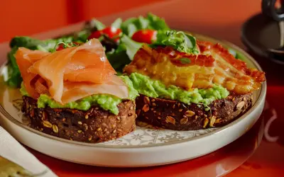 a plate with two sandwiches and a salad on a table at Residenza Piranesi Boutique Hotel in Rome