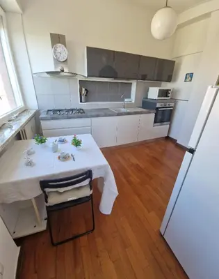 a kitchen with a white table and a refrigerator at appartamento panoramico su Roma in Rome