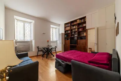 a living room with a bed and a table with chairs at GuestHost - Tra Castel Sant'Angelo e Città del Vaticano Flat in Rome