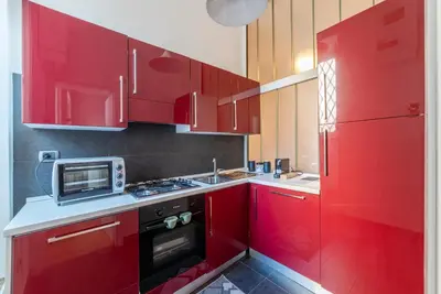 a kitchen with red cabinets and a microwave at GuestHost - Tra Castel Sant'Angelo e Città del Vaticano Flat in Rome