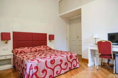 a bedroom with a red bed and a red chair at Domus Lilium in Rome