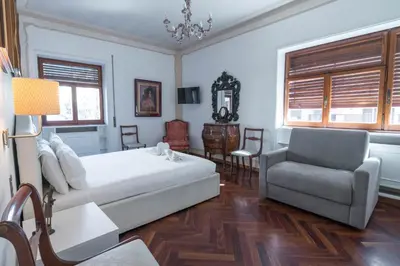a bedroom with a bed and a chair and a couch at The Majestic Residence in Vatican in Rome