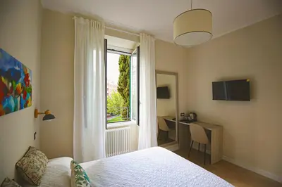 a bedroom with a bed and a window and a desk at Colosseum Maison in Rome