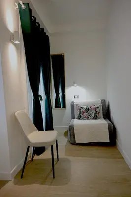 a bedroom with a bed and a chair in a room at Colosseum Maison in Rome