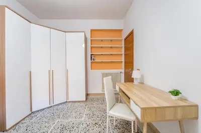 a dining room with a wooden table and white cabinets at Luigi's Home, Cozy Apartment Metro San Paolo in Rome