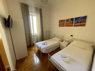 a small room with two beds and a television at A due passi da San Pietro in Rome