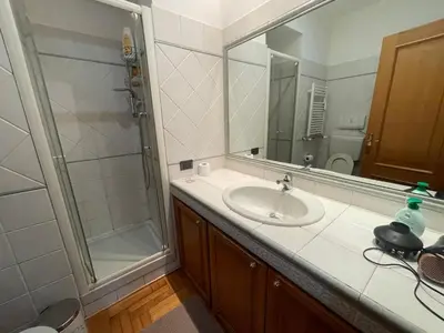a bathroom with a sink and a shower with a mirror at A due passi da San Pietro in Rome