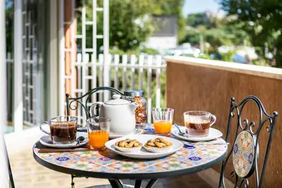 a table with a breakfast of tea and biscuits and coffee at Cozy flat 2 bedrooms 2 bathrooms with balcony in Rome