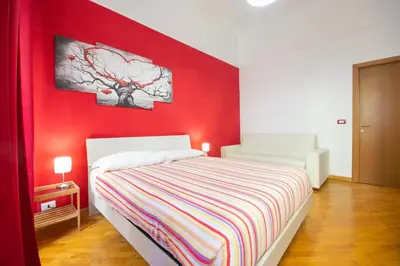 a red bedroom with a bed and a red wall at Vatican Apartment - Sister's Place in Rome