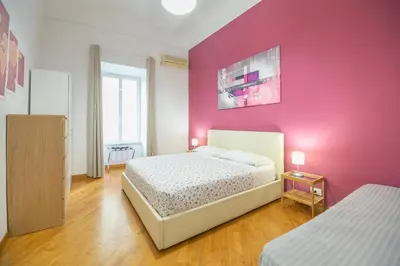 a bedroom with two beds and a pink wall at Vatican Apartment - Sister's Place in Rome
