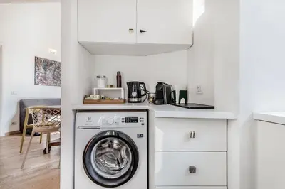a kitchen with a washing machine in a white kitchen at Casa Caracciolo Roma Vaticano in Rome