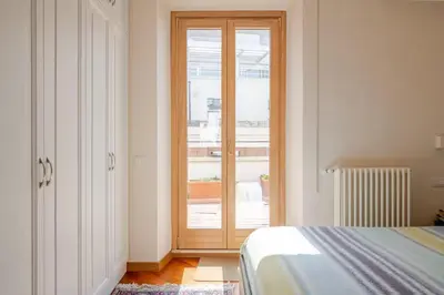 a bedroom with a sliding glass door with a window at Via Umbria 25 Luxury Suites in Rome