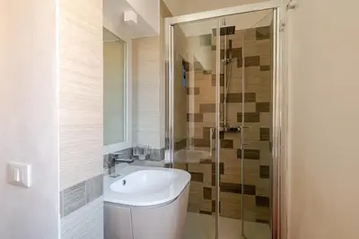 a white bathroom with a sink and a shower at Via Umbria 25 Luxury Suites in Rome