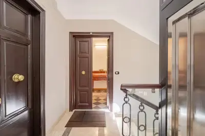 a hallway with a wooden door and stairs at Via Umbria 25 Luxury Suites in Rome