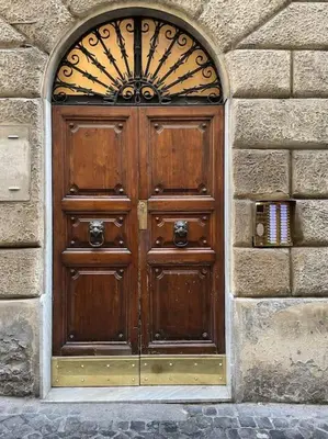 a large wooden door in a stone wall at Elian Apartament In The Center of Rome #2 in Rome