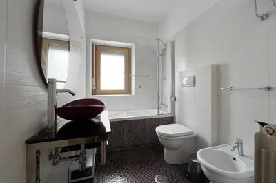 a bathroom with a sink toilet and a mirror at La Casa di Roma in Rome