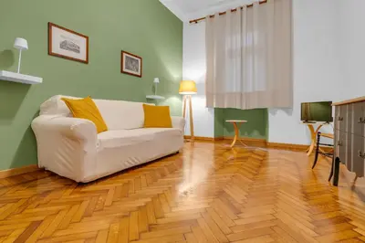 a living room with a white couch and a wooden floor at CASA REMO - for family, 2 bathrooms, AC, self check-in in Rome