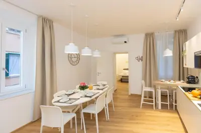 a kitchen and dining room with a white table and chairs at Colosseum Holidays - Three-Bedroom Apartment in Rome